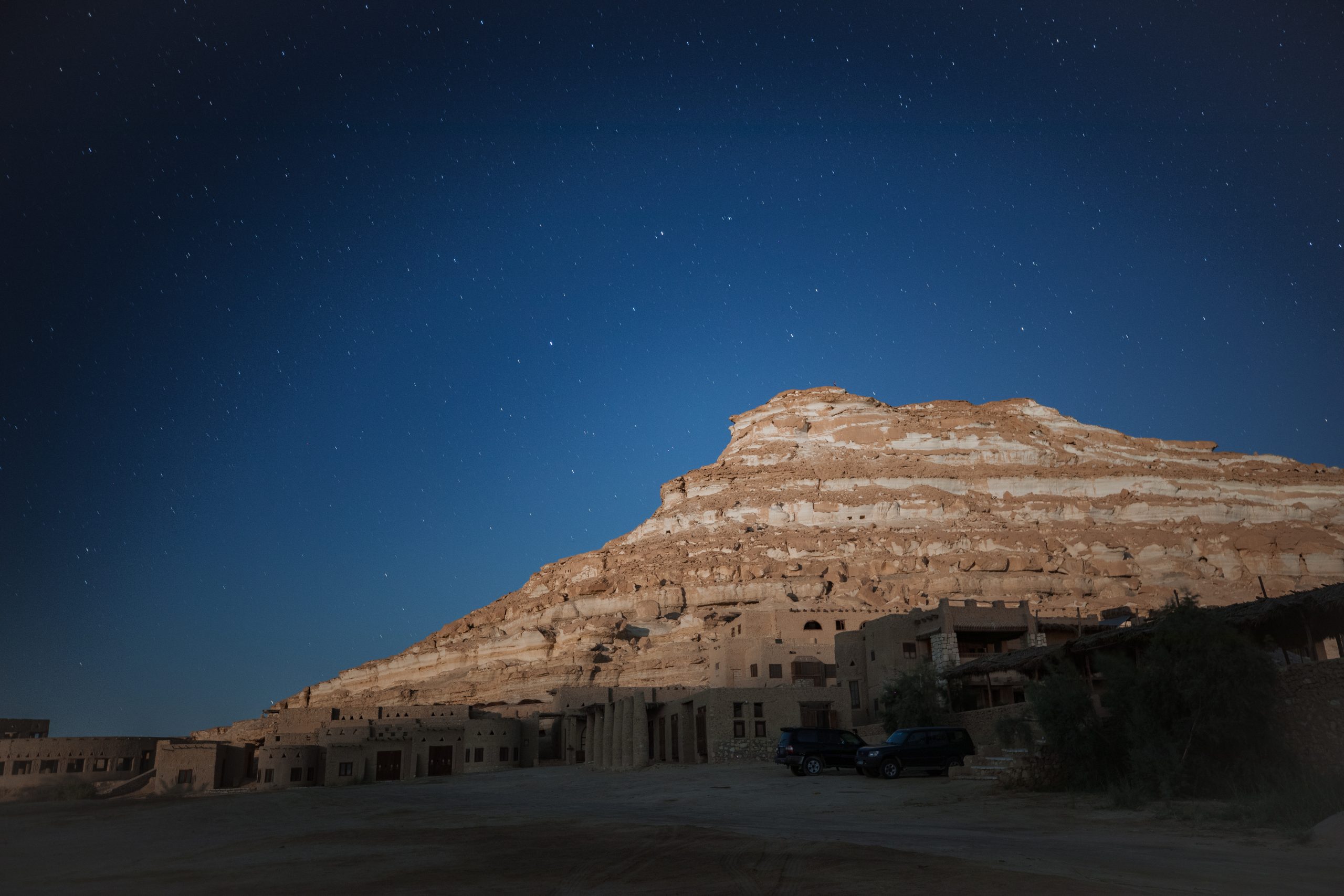 Taziry Ecolodge has been built at the footstep of the famous Red Mountain of Siwa (Taziry), facing the magnificent White Mountain (Gafar), overlooking the vast salt lake, and the timeless dunes of the Great Sand Sea. “Taziry” in Siwi means “full moon”.